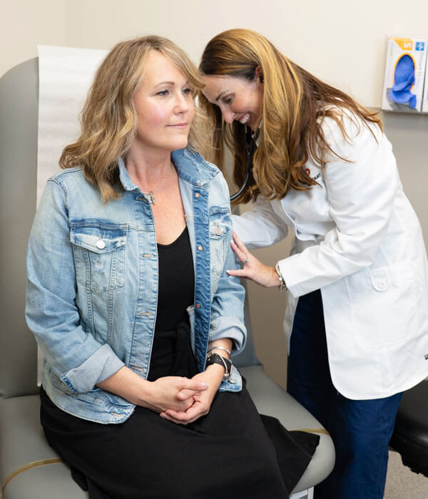 Dr. Anne Ford listening to a woman's heartbeat