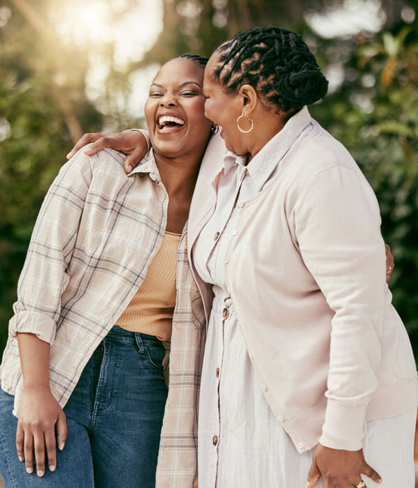two women smiling and laughing outdoors