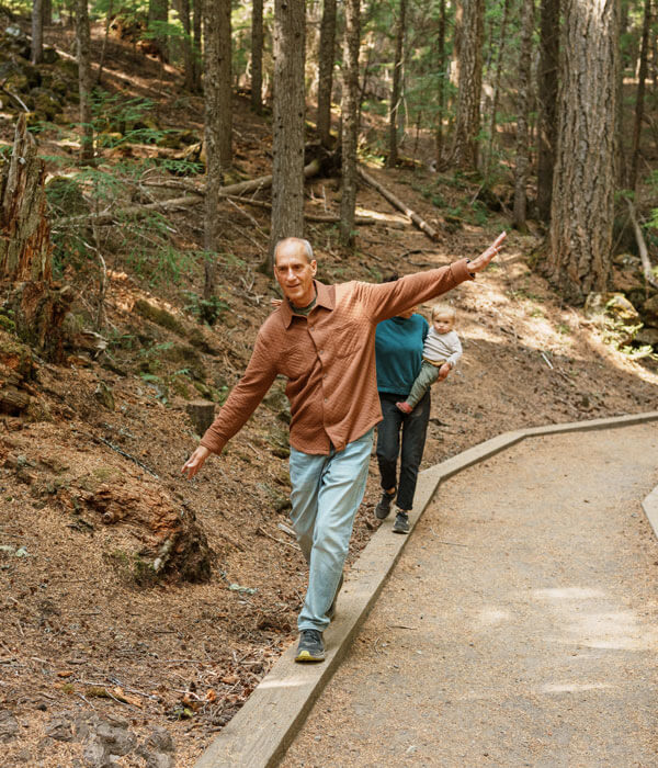 a family walking along the wooden border of a walkway