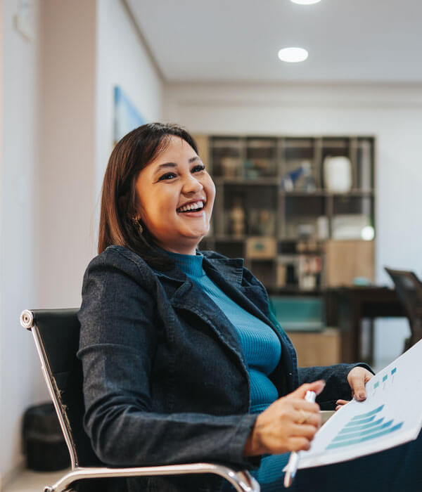 woman holding a chart in a business meeting and smiling