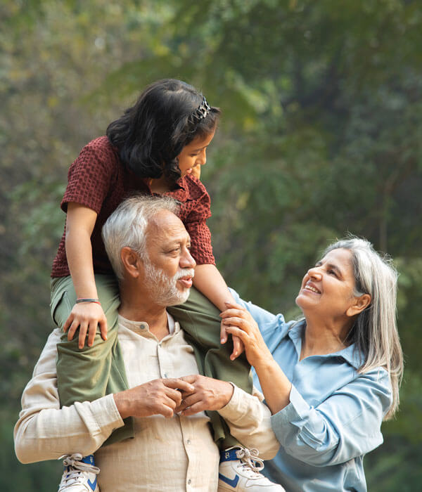 grandparents walking outdoors with their grandchild