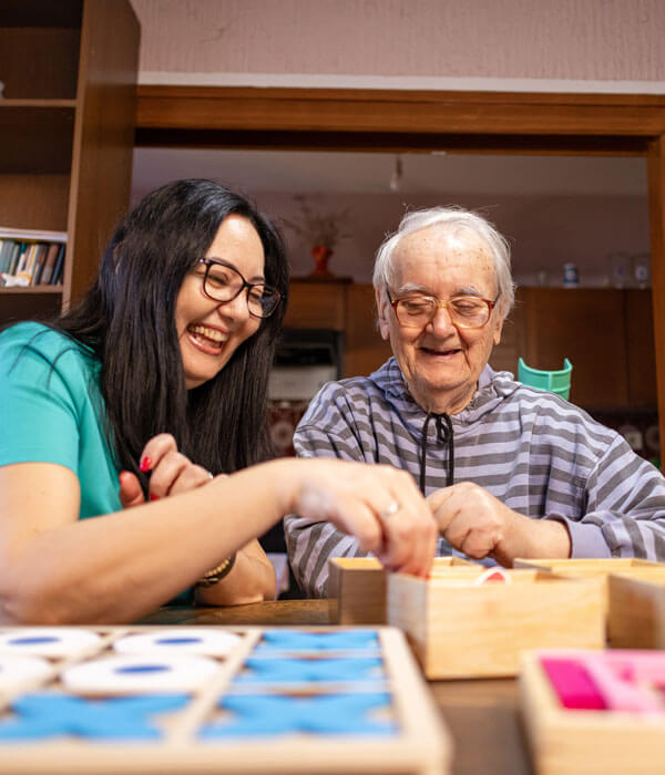 adult daughter and elderly parent playing tabletop games