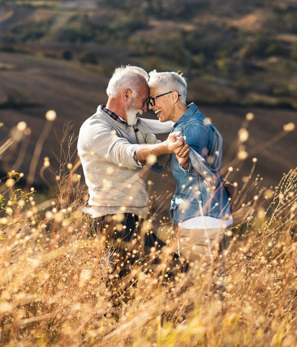 older couple dancing in a meadow